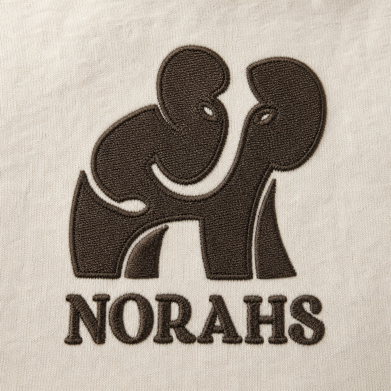 Close-up of Brunette Brown elephant embroidery on natural Supima cotton