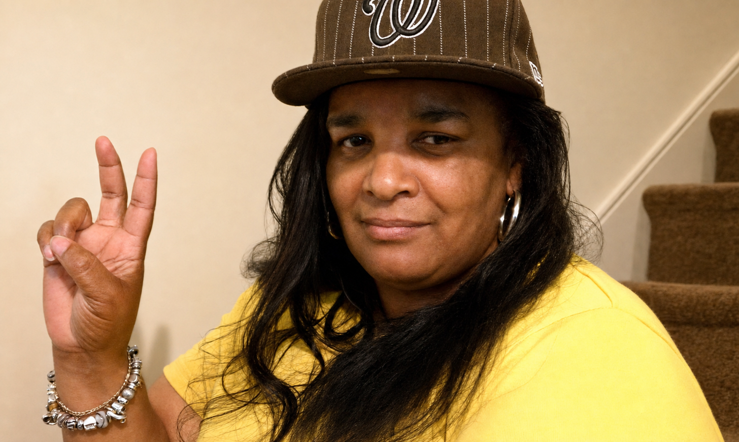 Sharon smiling and holding up a peace sign