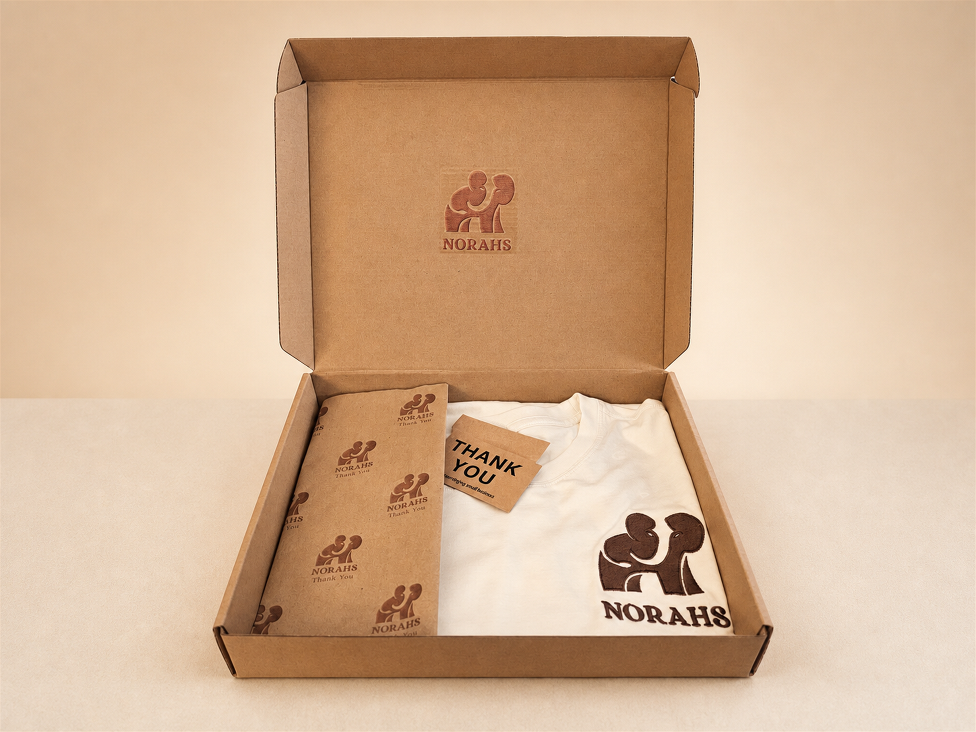Norahs Signature Supima Tee presented in branded kraft packaging.